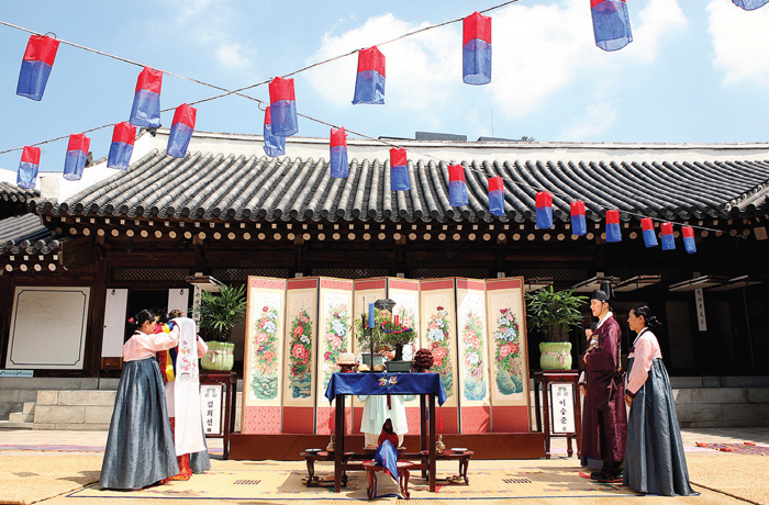 Traditional Wedding-The traditional Korean wedding ceremony largely consists of three stages: Jeonallye, in which the groom visits the bride’s family with a wooden goose; Gyobaerye, in which the bride and groom exchange ceremonious bows; and Hapgeullye, where the marrying couple shares a cup of wine. The photo shows a bride and groom exchanging ceremonious bows during the Gyobaerye stage of their wedding ceremony.